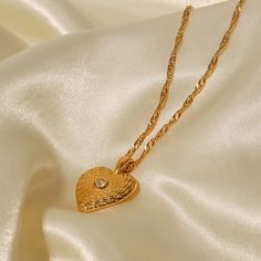 The Heart Necklace, in 18k gold plating, is an elegant symbol of love and affection. Its classic heart-shaped pendant adds a romantic touch to any look, making it perfect for everyday wear or special moments. Gold Heart Necklace With Round Pendant, Tarnish Resistant, Gold Heart Necklace With Tarnish Resistant Round Pendant, Elegant Gold Plated Heart Pendant Necklace, Yellow Gold Plated Heart Necklace With Clavicle Chain, Classic Gold Heart Necklace With Delicate Chain, Classic Gold Heart Necklace For Everyday, Elegant Gold-plated Yellow Gold Heart Necklace, Elegant Gold Plated Charm Necklaces For Valentine's Day, Elegant Yellow Gold Plated Heart Necklace