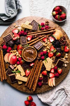 a platter filled with fruit, crackers and chocolate on top of a table