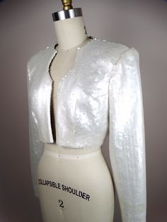 "This is a gorgeous couture vintage bolero jacket fully embellished with pearlescent ivory sequins. It's in perfect condition! Very well made! There are no closures, so measurements are taken with the front brought together. Bust - 36/38\" Shoulders - 16\" Sleeves - 24\" Length - 14\" Tag Size - 8 All of my items come from a smoke-free and pet-free home. If you have any questions, please don't hesitate to ask!" Embellished Fitted Party Outerwear, Fitted Embellished Outerwear For Party, Fitted Embellished Party Outerwear, White Sequined Outerwear For Party, Glamorous Embellished Wedding Outerwear, Fall Wedding Outerwear With Sequins, Elegant White Sequined Outerwear, Embellished Fitted Outerwear For Wedding, Fitted White Embellished Outerwear