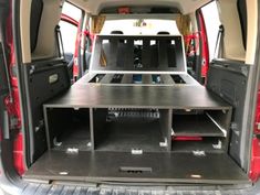 the back end of a van with its cargo compartment open and two seats folded down