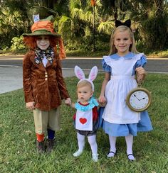 three children dressed up in costumes standing next to each other