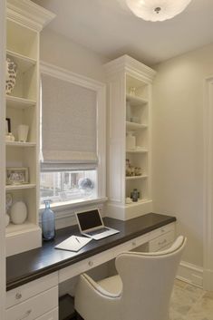 a laptop computer sitting on top of a desk next to a white chair and book shelf