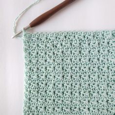 the crochet is being worked on with a knitting needle