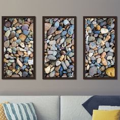 three panels with rocks in them hanging on the wall next to a couch and pillows