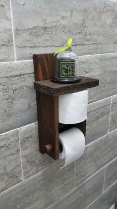 a toilet paper dispenser mounted to the side of a wall with a jar on it