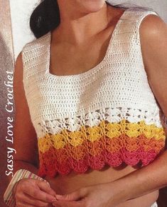 a woman is wearing a crocheted top and smiling