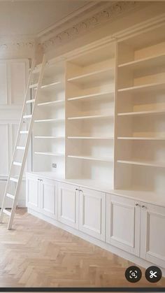 an empty room with white bookcases and stairs