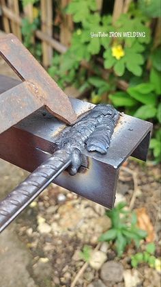 a metal object that looks like an alligator on a piece of wood with a knife sticking out of it