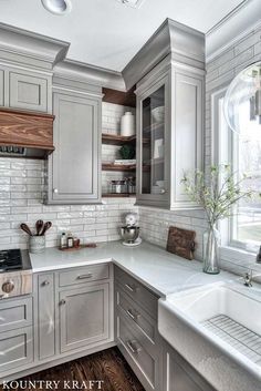 a kitchen with gray cabinets and white counter tops