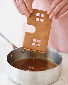 someone is making a gingerbread house out of paper and baking it in a pan