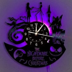 the nightmare before christmas clock is lit up with purple light and silhouettes on it