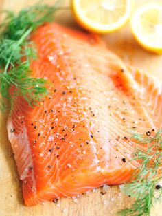 fresh salmon with herbs and lemons on a cutting board