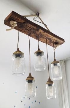 three mason jar lights hanging from a wooden beam