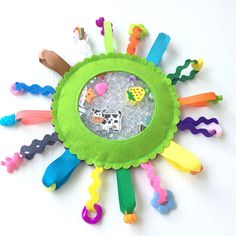 a green toy with lots of different colored toys on it's face and around the edges