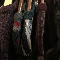 several different colored knitted umbrellas hanging on a rack