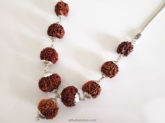 Navgrah Rudraksha Beads Kantha Mala- (Siddha mala) is a Powerful and unique Rudraksha Navagraha Kantha. This Navgrah Rudraksha Beads Kantha consists of Rudrakshas from 2 Mukhi to 9 mukhi (1 each) + 12 Mukhi. There is a silver chain attached to the pendant. This Siddh Mala Silver Pendant appease all the negative planets and gives power to benefic planets. Navgarh Rudraksha kantha is the one pendant, which should definitely be worn by everyone. It does not have any negative effect. It would defini Silver Mala With Round Beads For Meditation, Spiritual Silver Beaded Necklaces For Puja, Silver Spiritual Beads For Festivals, Spiritual Necklaces With Silver Beads For Puja, Silver Beaded Necklaces For Rituals And Festivals, Silver Temple Jewelry Beads Gift, Traditional Silver Mala For Meditation, Silver Spiritual Beaded Necklace For Rituals, Silver Temple Jewelry Beads For Festivals