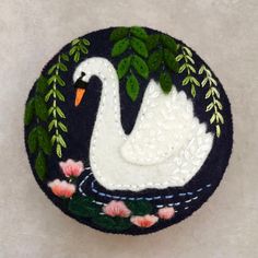 a white swan sitting on top of a black plate