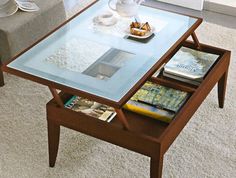 a glass table with books on it and a remote control sitting on top of it