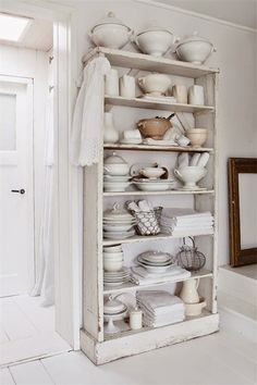 a white shelf filled with lots of dishes