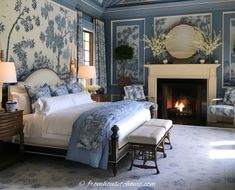 a bedroom decorated in blue and white with a fireplace