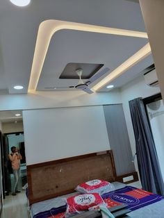 a bed room with a neatly made bed and a ceiling fan