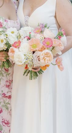 two bridesmaids holding bouquets of flowers in their hands