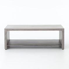 a concrete coffee table with two shelves on each side