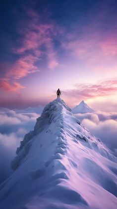 a man standing on top of a snow covered mountain under a purple sky with clouds