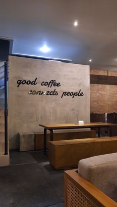 a coffee shop with tables and benches in front of a wall that says good coffee on it