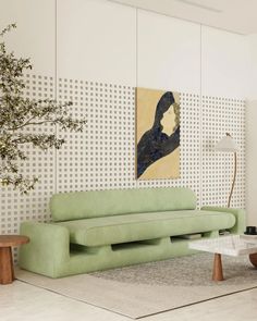 a living room with a green couch and coffee table in front of a painting on the wall