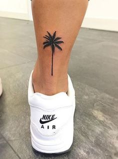 a small palm tree tattoo on the ankle