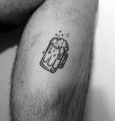 a black and white photo of a man's legs with a beer tattoo on it