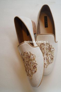 pair of white shoes with embroidered flowers on them