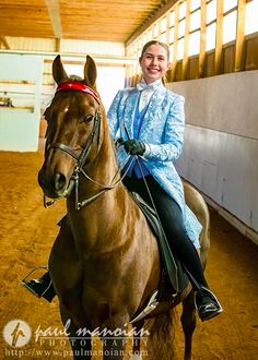 a woman riding on the back of a brown horse