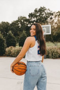 a woman holding a basketball in her right hand