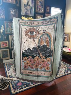 a tapestry with an image of the sun and clouds on it in a room full of pictures