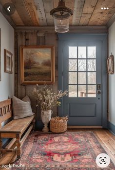 a room with a blue door and rug on the floor next to a wooden bench