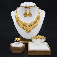 Indulge in luxury with this exquisite Dubai Gold Necklace Set, perfect for wedding parties. With its opulent design and superior craftsmanship, this set features a necklace, bracelet, earrings, and ring. Make a lasting impression and elevate your style with this luxurious jewelry set." Gold Plated Costume Bridal Sets, Gold Fine Jewelry For Wedding, Gold Bridal Sets With Elegant Design, Gold Plated Elegant Costume Jewelry, Yellow Gold Plated Costume Jewelry Set, Gold Jewelry With Elegant Design For Wedding, Gold-plated Yellow Gold Costume Jewelry Sets, Gold-plated Gold Costume Jewelry Sets, Hand Set Gold Plated Costume Jewelry