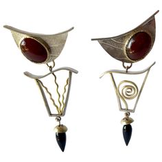 Hand made sterling silver, 14k gold, carnelian and onyx post modernist earrings created by artist and jeweler Enid Kaplan of New York City, New York. Earrings are entitled "Synergy" and measure 3" long by 1.5" wide. They are of the pierced variety and are signed E. Kaplan, 1999. In very good, unworn vintage condition. From the estate of the artist, Enid Kaplan. Enid Kaplan was a New York City studio jeweler, sculptor and mixed-media artist who taught, lectured and exhibited all over the world. H Modern Carnelian Jewelry For Formal Occasions, Modern Carnelian Jewelry With Polished Finish, Modernist Earrings, Parsons School Of Design, Fashion Institute, City New York, American Crafts, Mixed Media Artists, Rhode Island