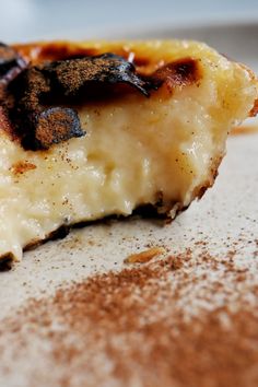 a piece of food that is sitting on a white plate with some brown stuff around it