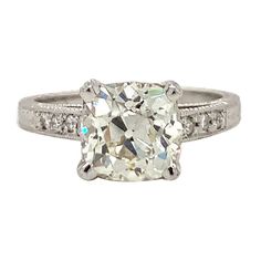 This alluring and pristine engagement ring is a beautiful fusion of antique charm and contemporary craftsmanship, set in elegant platinum. The centerpiece is a stunning 2.14-carat old European cut diamond, prong set to maximize its vintage brilliance. With a warm L-M color and VS-2 clarity, this diamond exudes a romantic, glimmering glow that is truly captivating. Accentuating the center stone are six round brilliant-cut diamonds totaling 0.10 carats, adding a delicate touch of sparkle that enha Classic Platinum Diamond Ring With Cushion Cut, Vintage Diamond Ring With Center Stone Cushion Cut, Vintage Cushion Cut Diamond Ring With Center Stone, Vintage Diamond Ring With Cushion And Brilliant Cut, Classic Cushion Cut Diamond Ring With Single Cut Diamonds, Heirloom Diamond Ring With Cushion Cut, Heirloom Cushion Cut Diamond Ring With Center Stone, Heirloom Cushion Cut Single Diamonds Wedding Ring, Heirloom Silver Cushion Cut Diamond Ring