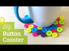 a cup filled with buttons sitting on top of a wooden table