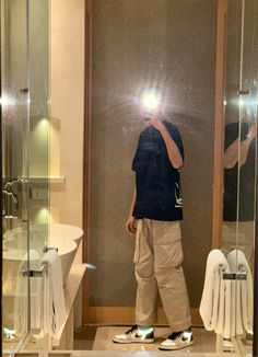 a man taking a selfie in front of a bathroom mirror