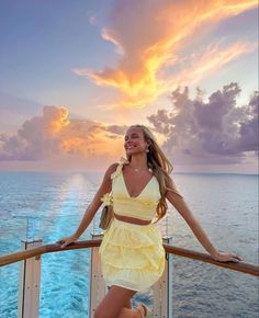 a beautiful woman standing on the deck of a cruise ship