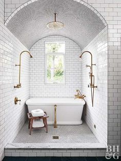 a bathroom with white tile and gold fixtures