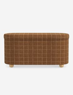 an upholstered bench with wooden legs and a brown checkered fabric seat cover