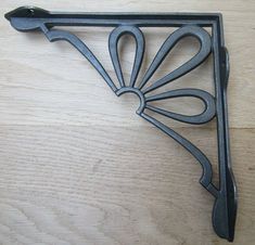 an iron shelf bracket on a wooden surface