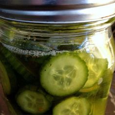 a jar filled with pickles sitting on top of a table