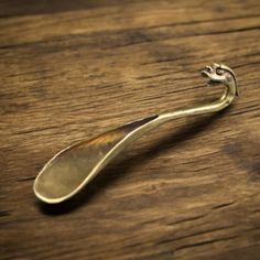 a metal spoon sitting on top of a wooden table