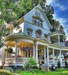 a large white house sitting on top of a lush green field